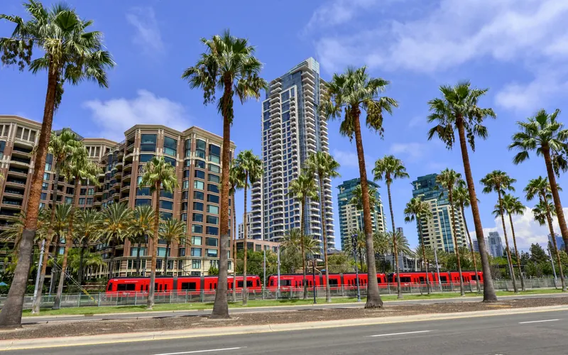 San Diego trolley passing palm trees and downtown high-rises